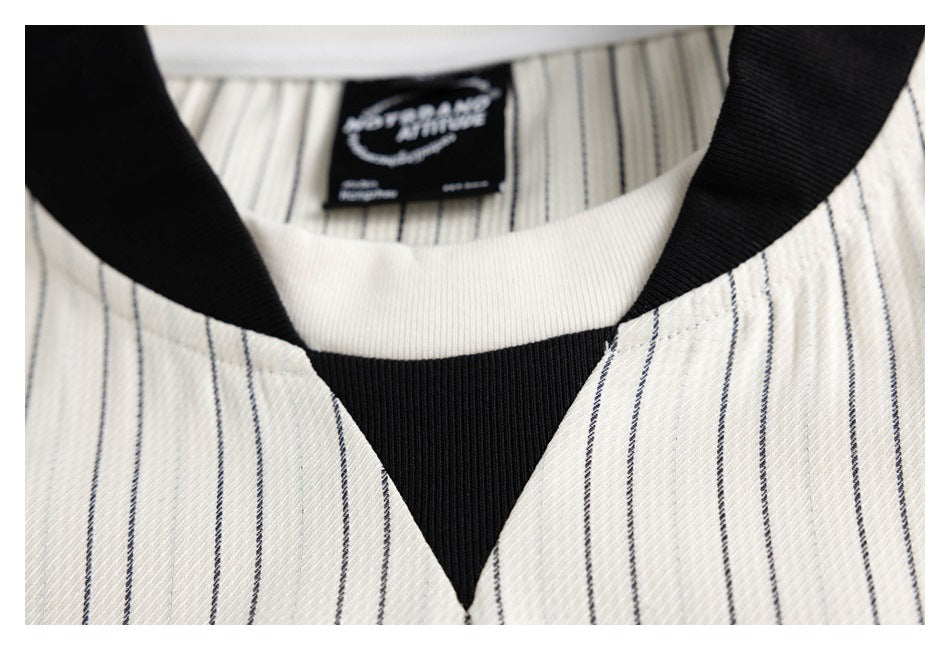 Close-up of an ivory pinstriped neckline with a black ribbed collar and contrasting white inner band.