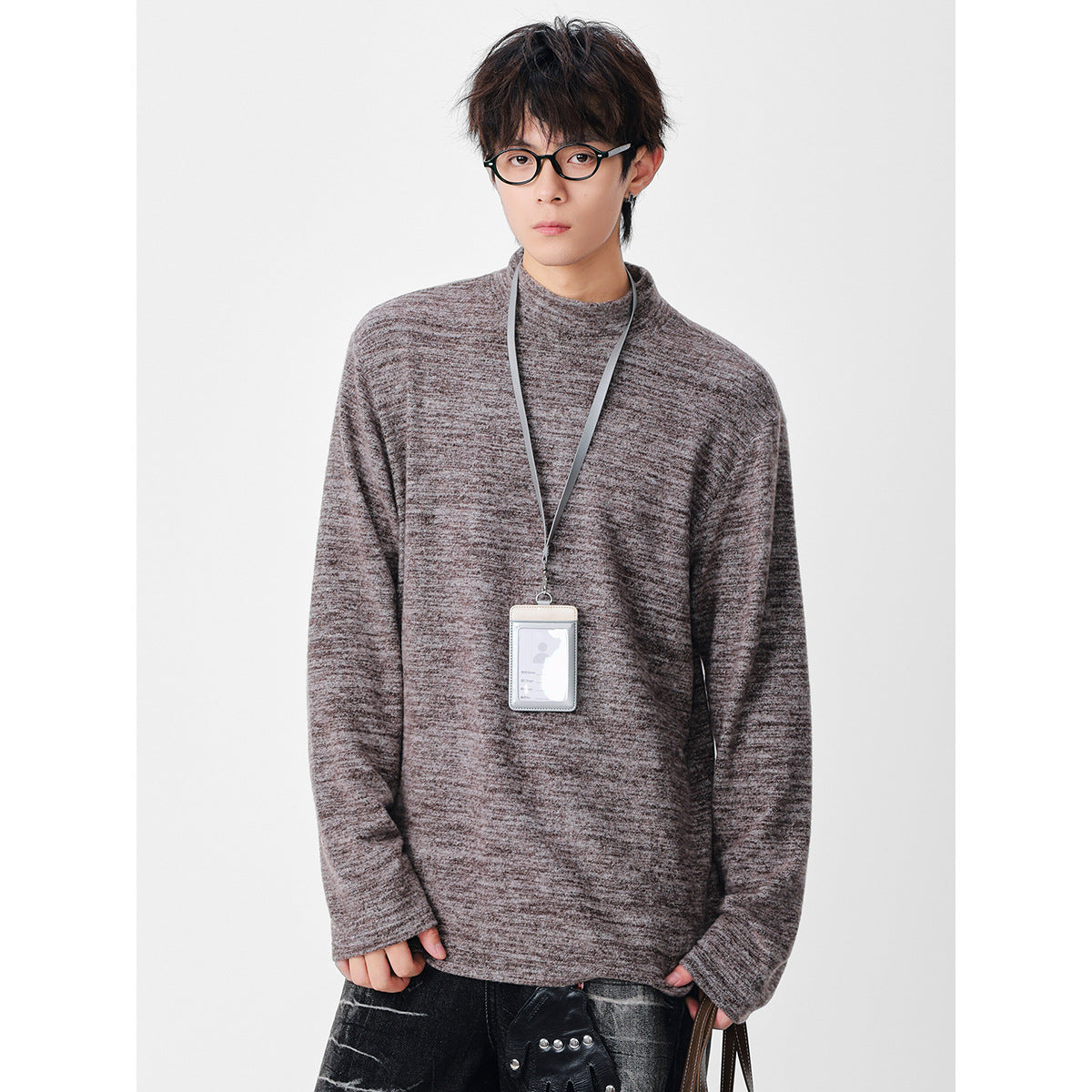 Model wearing an oversized taupe-gray marled long-sleeve top with a high round neckline.
