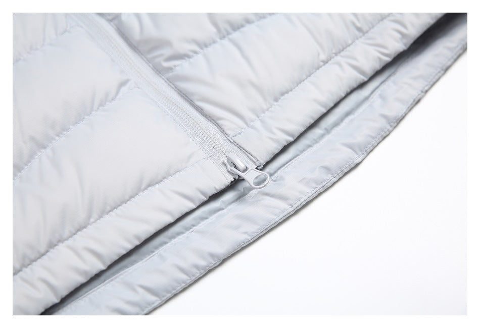 Close-up of a light gray quilted jacket with a matching zipper and large ring-shaped pull.