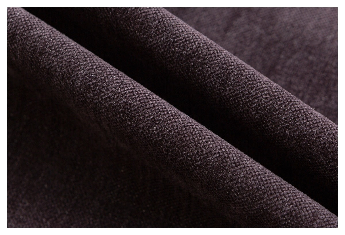 Macro view of dark plum-brown garment fabric folded to show its textured surface.