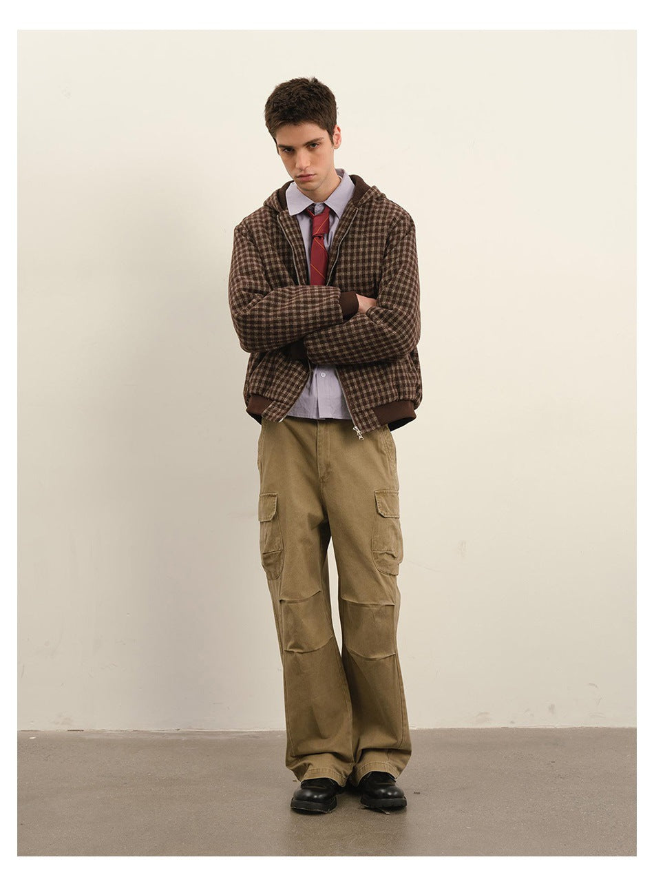 Model wearing a brown check hooded zip jacket with dark ribbed trim, paired with tan cargo pants.