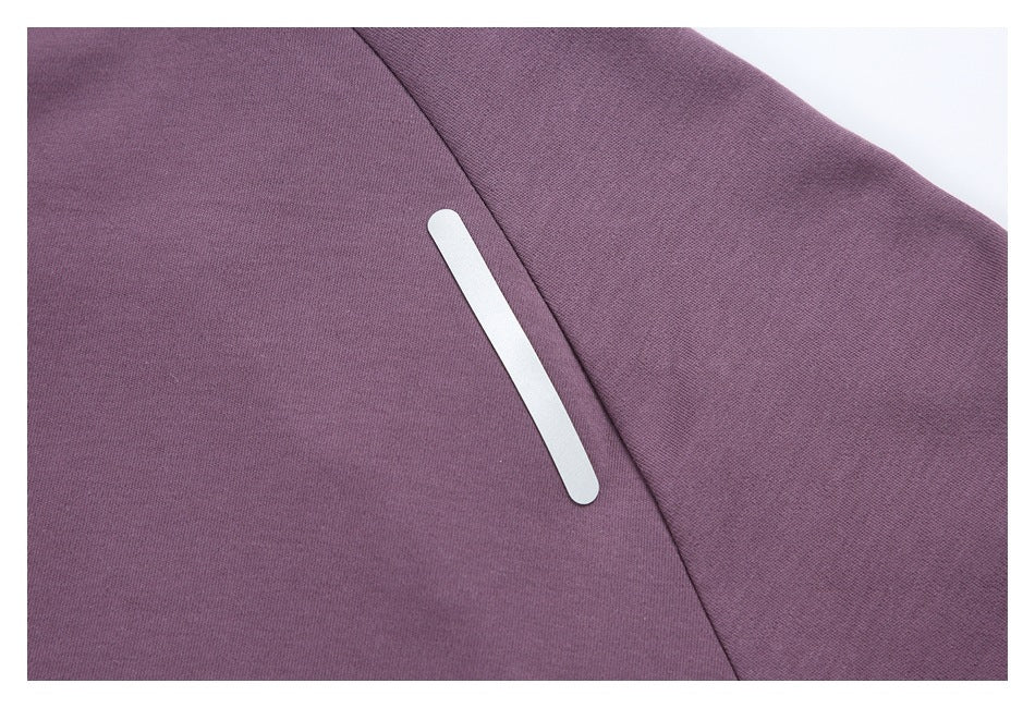 Close-up of a white reflective strip beside a seam on purple fabric.