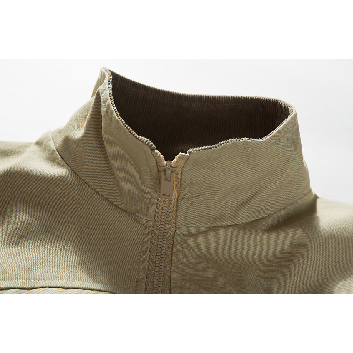 Close-up of a light khaki jacket's high collar, dark ribbed lining, and front zipper.