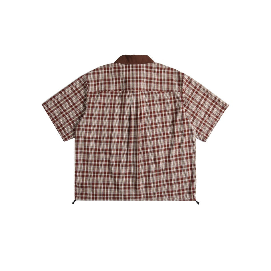 Back view of brown plaid short-sleeve shirt with back yoke, center pleat and hem drawcord toggles, flat lay
