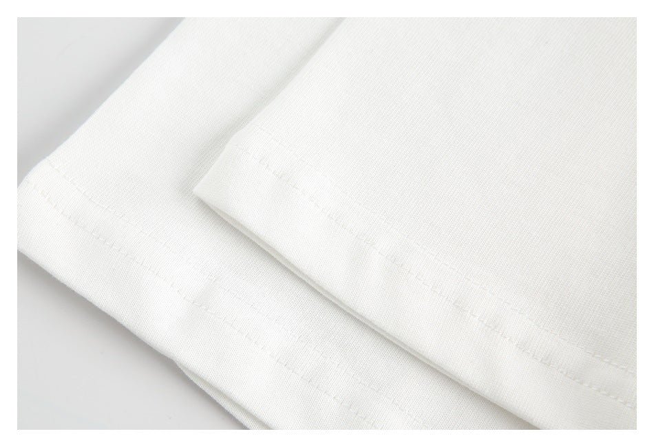 Close-up of the white top's stitched hem and fabric surface.