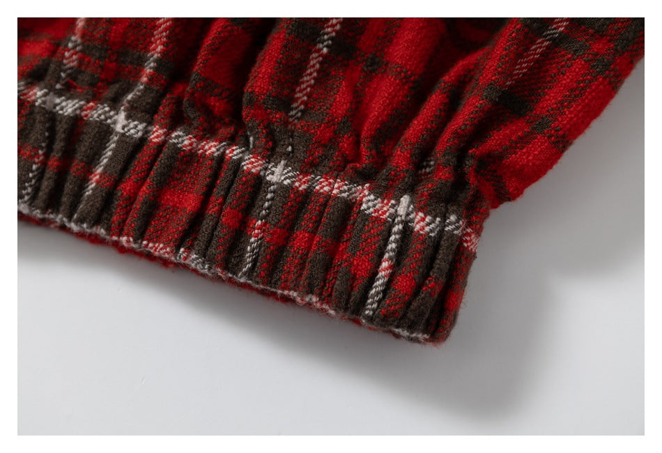 Close-up of a gathered edge on red, black, and white plaid fabric.