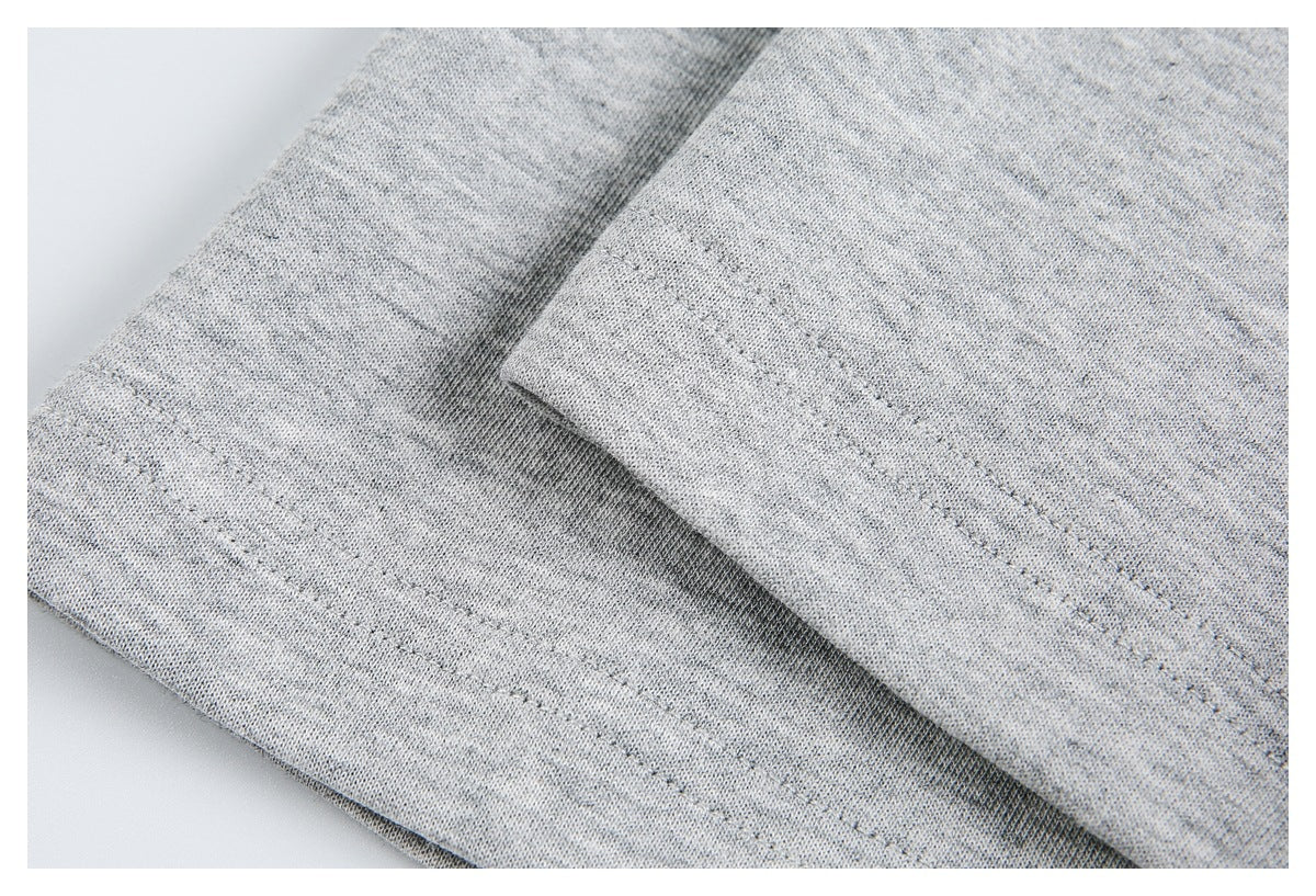 Close-up of folded light gray heathered knit fabric with stitched hems.