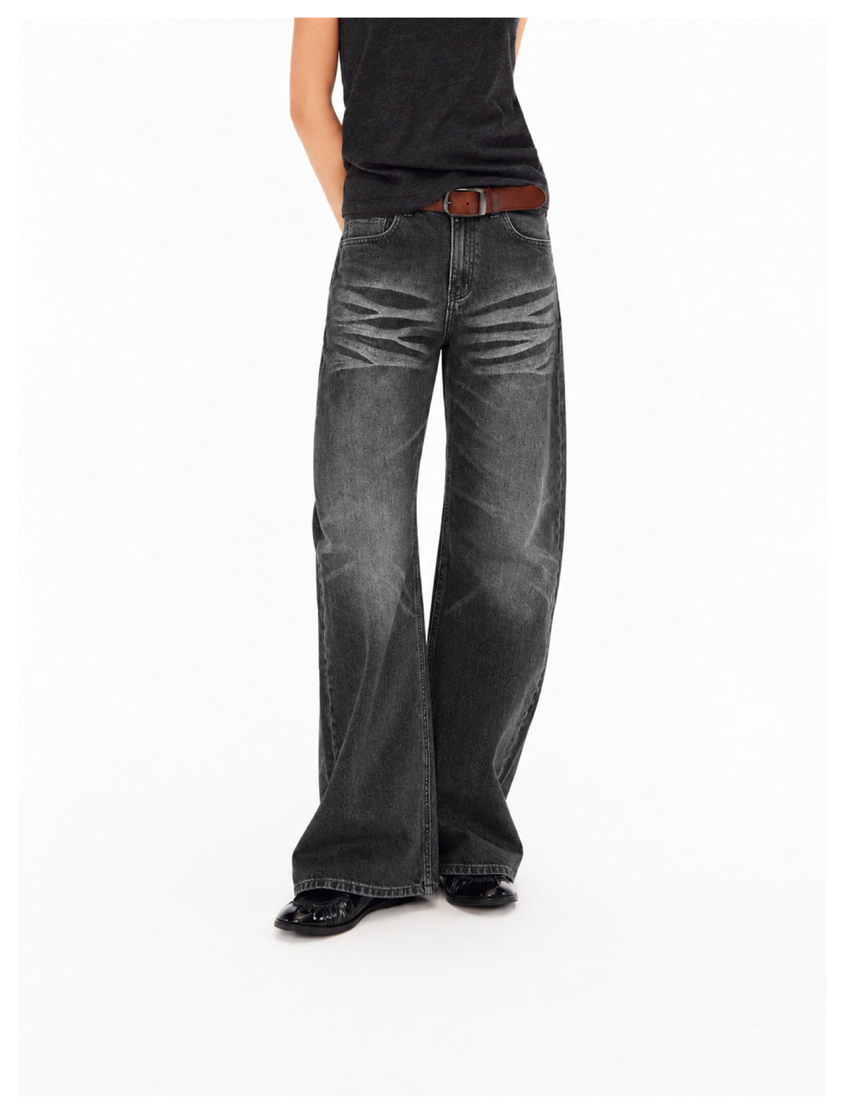 Front view of a person wearing charcoal wide-leg jeans with faded stripe details and a brown belt.
