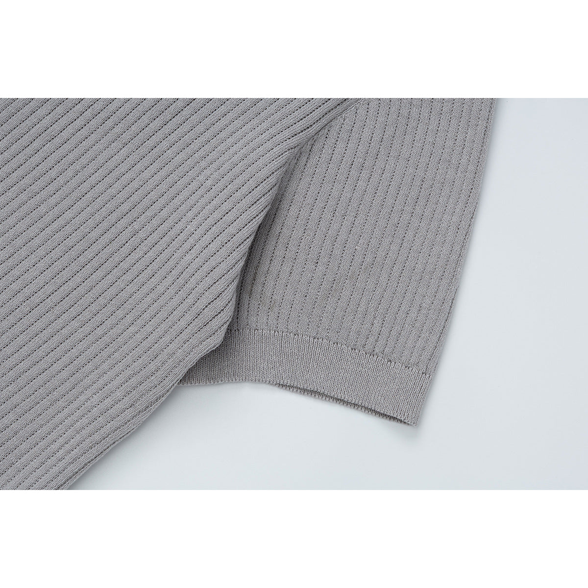 Close-up of the gray ribbed knit T-shirt sleeve and finished cuff.