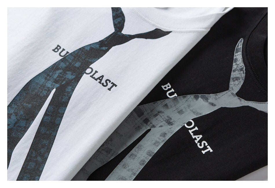 Close view of white and black T-shirts with large abstract dark graphics and English lettering.