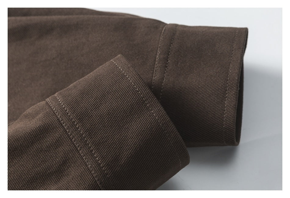 Close-up of a folded dark brown cuff showing its stitched edges and double seams.