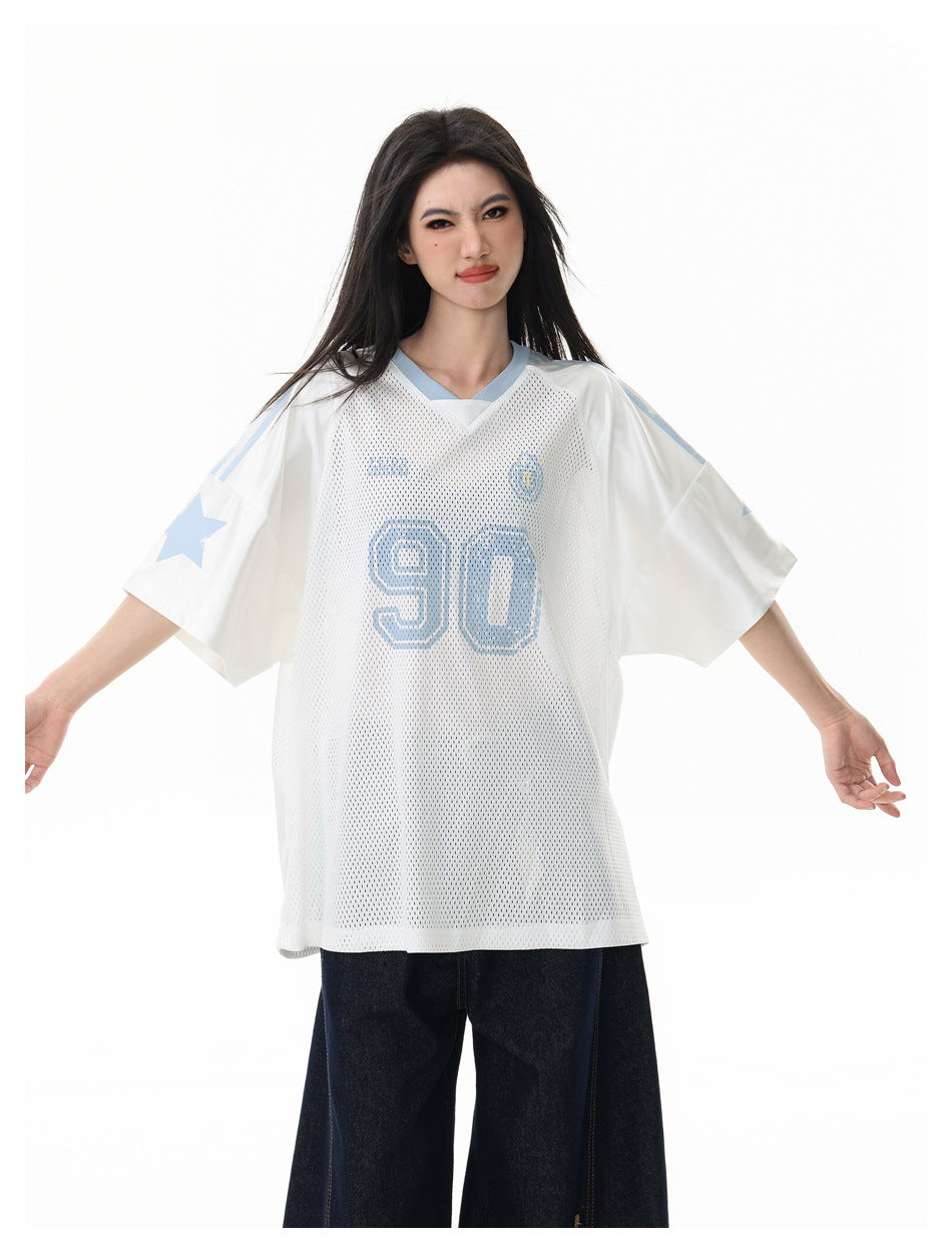 Model wearing a white mesh jersey with pale blue V-neck trim, star sleeve graphics and a large number 90.