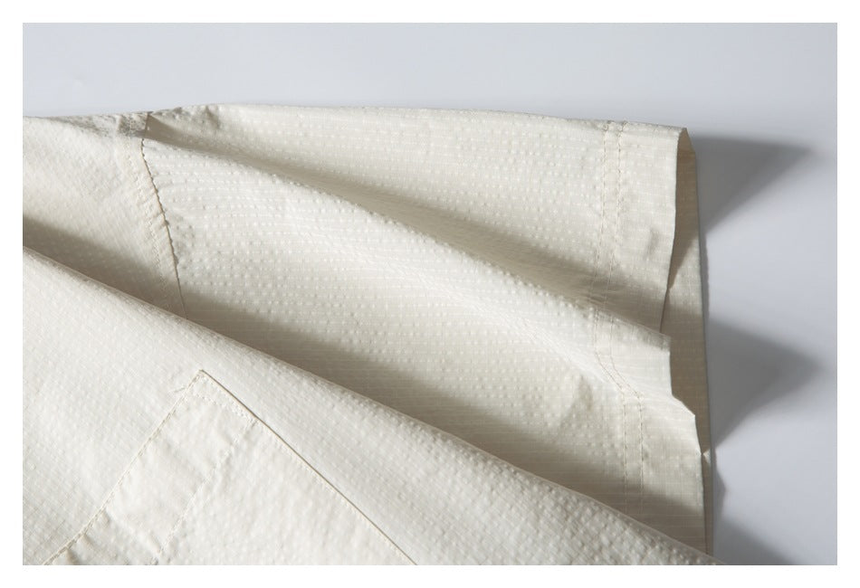Close-up of the ivory shirt's short sleeve and textured fabric.