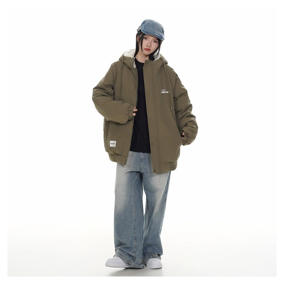 Model wearing an olive hooded jacket with cream lining, a denim cap, and loose light-wash jeans.
