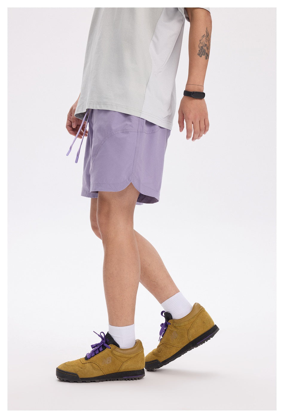 Side view of a person wearing lavender shorts with a curved side seam and split hem.