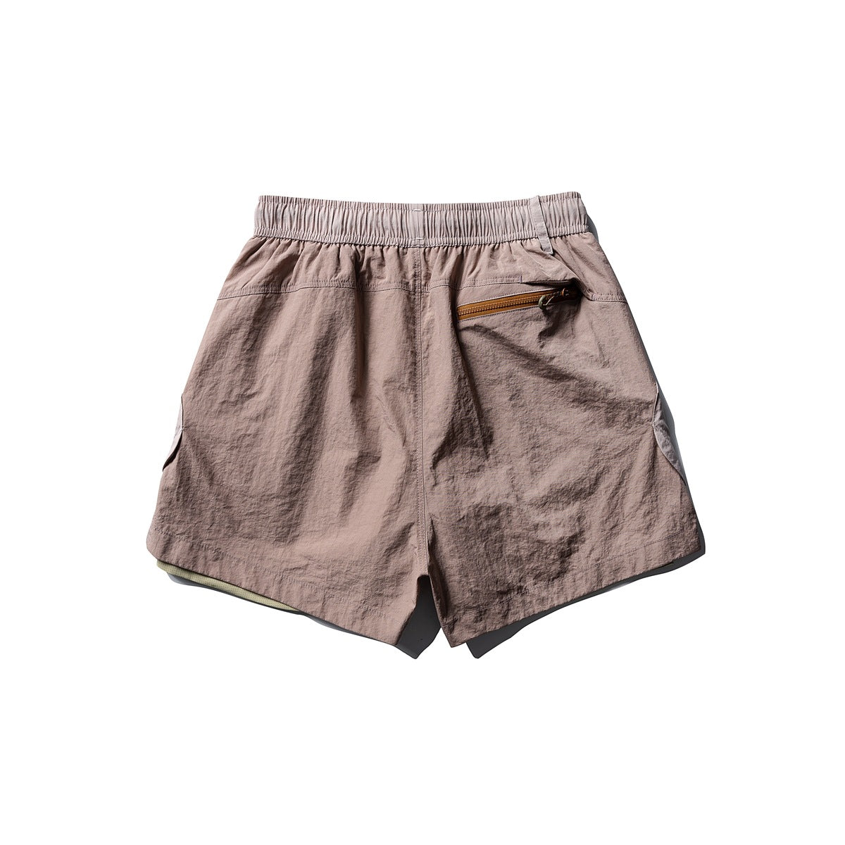 Back view of dusty mauve athletic shorts with a pale elastic waistband and an angled zip pocket.