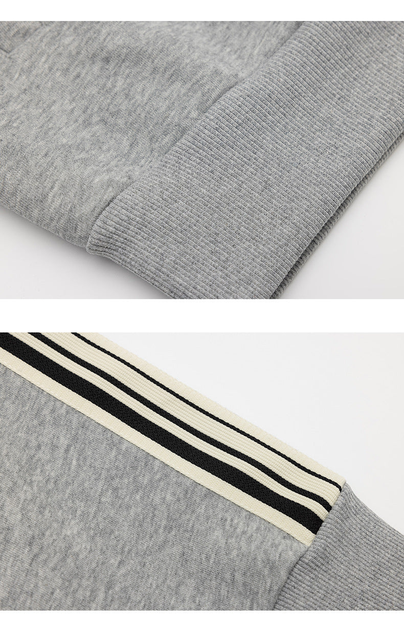 Close-up details of a heather-gray jacket's ribbed cuff and cream-and-black striped sleeve trim.