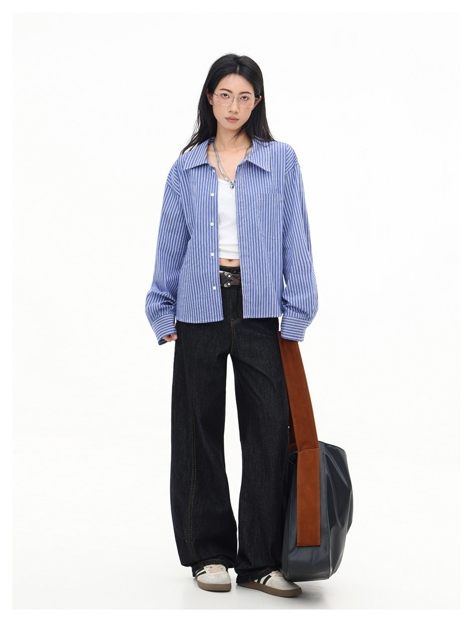 Model wearing the blue striped cropped shirt open over a white top with black wide-leg jeans and a tote bag