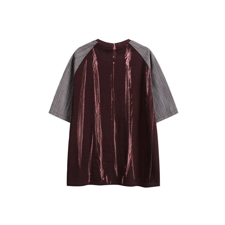 Back view of a deep burgundy oversized T-shirt with striped raglan sleeves and pinkish vertical streaks.