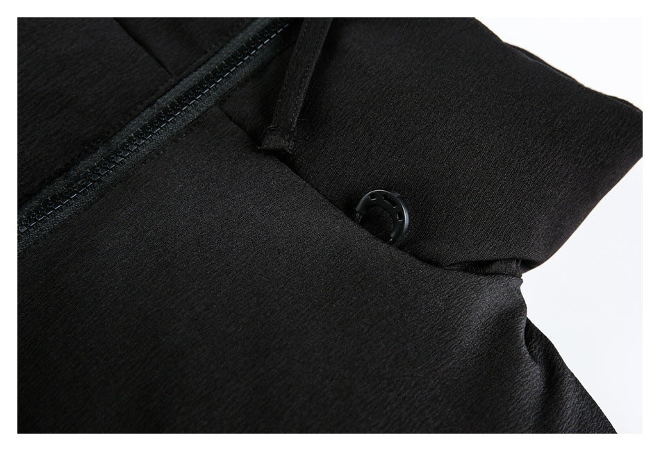 Close-up of a black padded jacket showing its zipper, collar strap and snap fastener.
