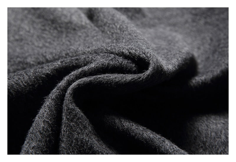 Macro view of the fuzzy, mottled charcoal gray fabric gathered into folds.