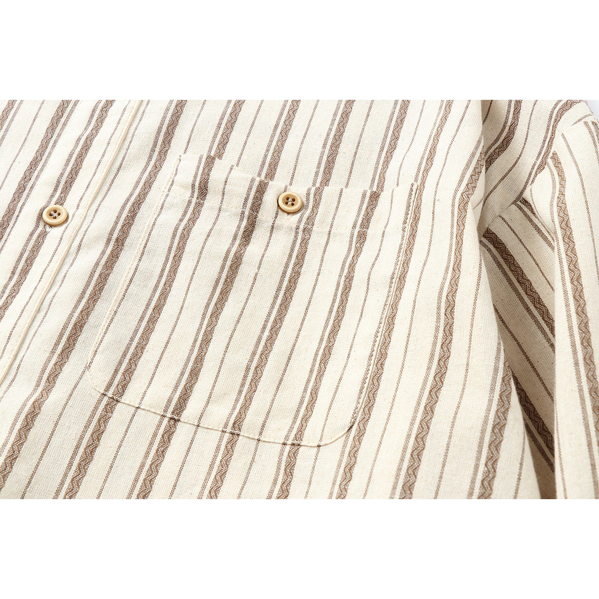 Close-up of a cream shirt's buttoned chest pocket and brown striped pattern.