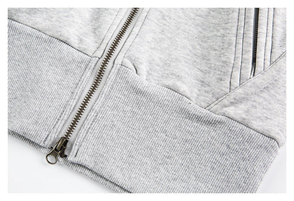 Close-up of the light gray jacket's ribbed hem, metal zipper, and sleeve cuff.