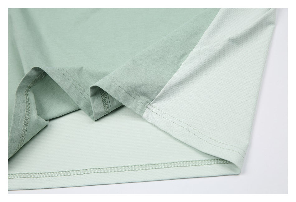 Close-up of the shirt's lower hem and sleeve, showing the pale sage and lighter mesh-textured panels.