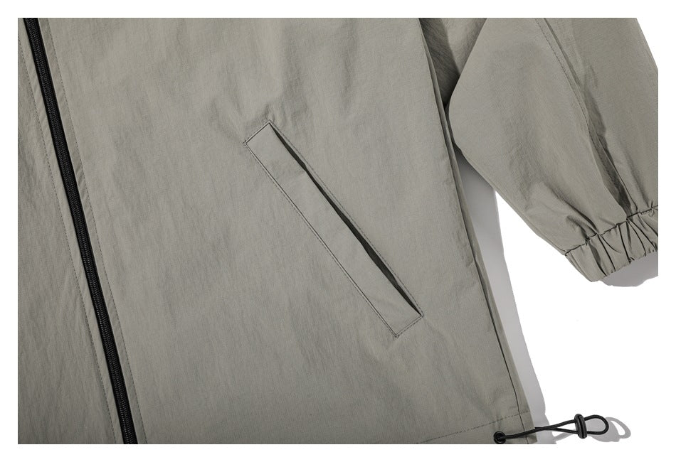 Close-up of the jacket's slanted pocket, gathered sleeve cuff, and adjustable hem cord.