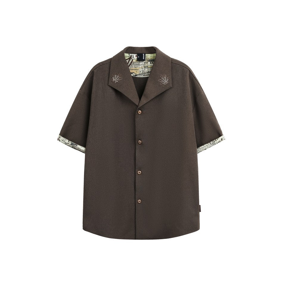 Mocha brown short-sleeve shirt with cuffs turned up to show printed town-scene lining, embroidered collar and buttons