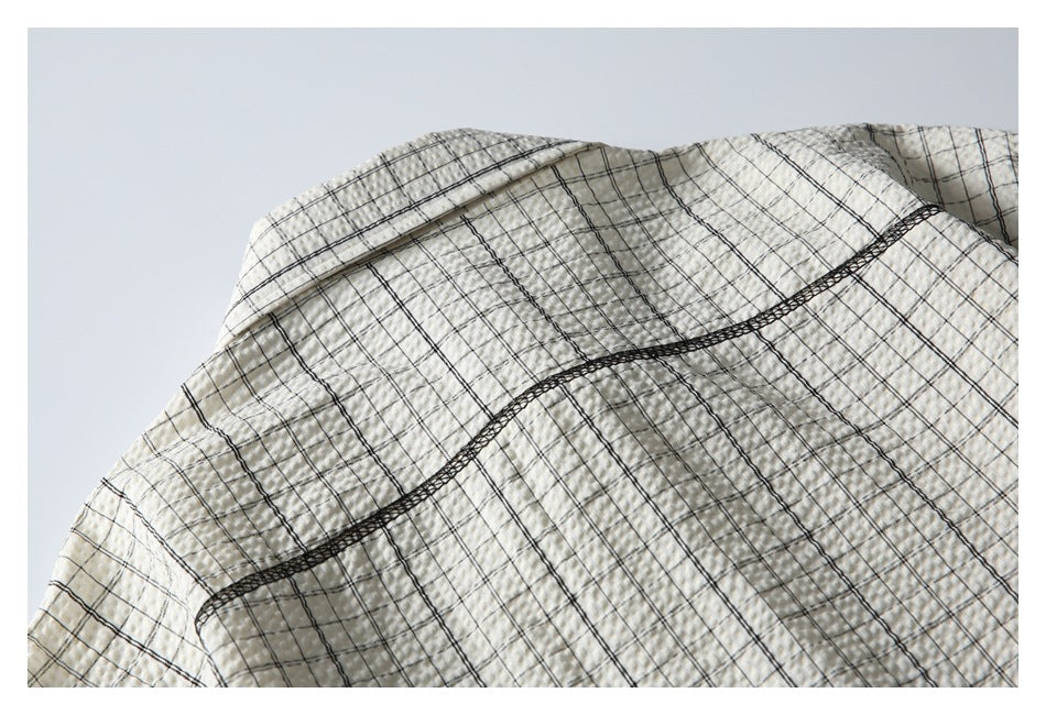 Close-up of the shirt's back shoulder area, showing a curved yoke seam on black-check fabric.