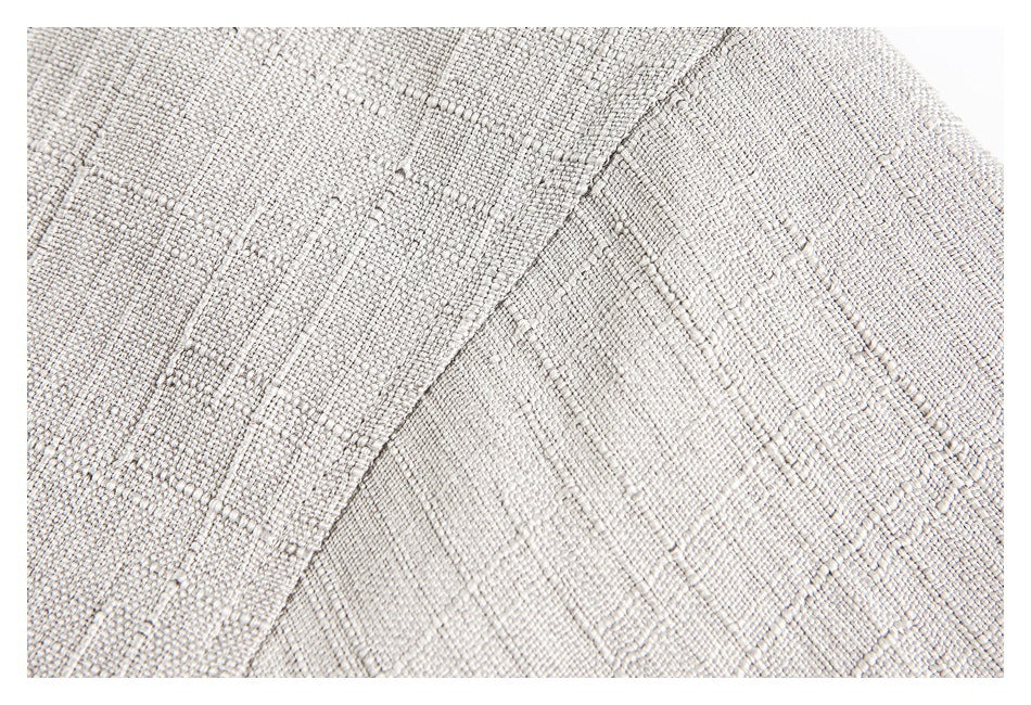 Close-up showing the cream garment's textured fabric and curved seam.