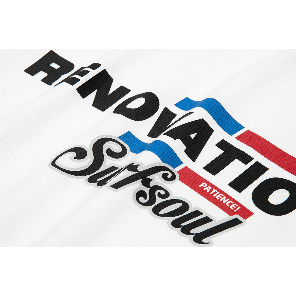 Close-up of a white T-shirt with bold black lettering and blue and red graphic accents.