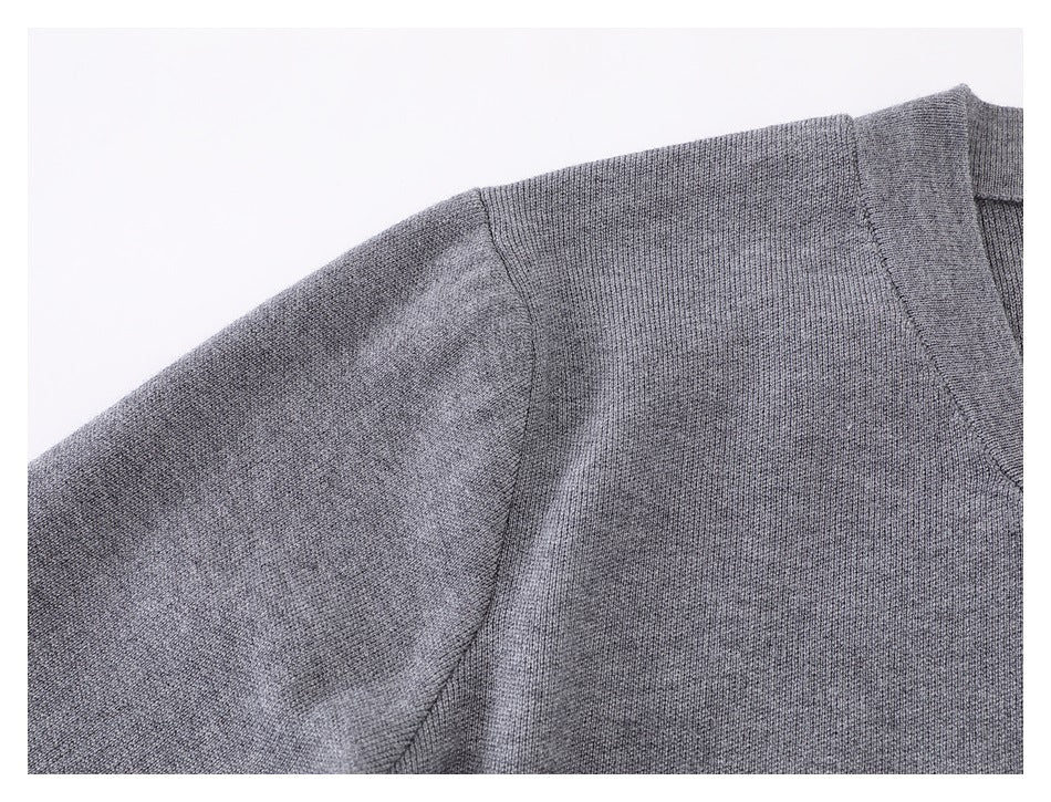Close-up of the gray knit cardigan's shoulder seam and sleeve.