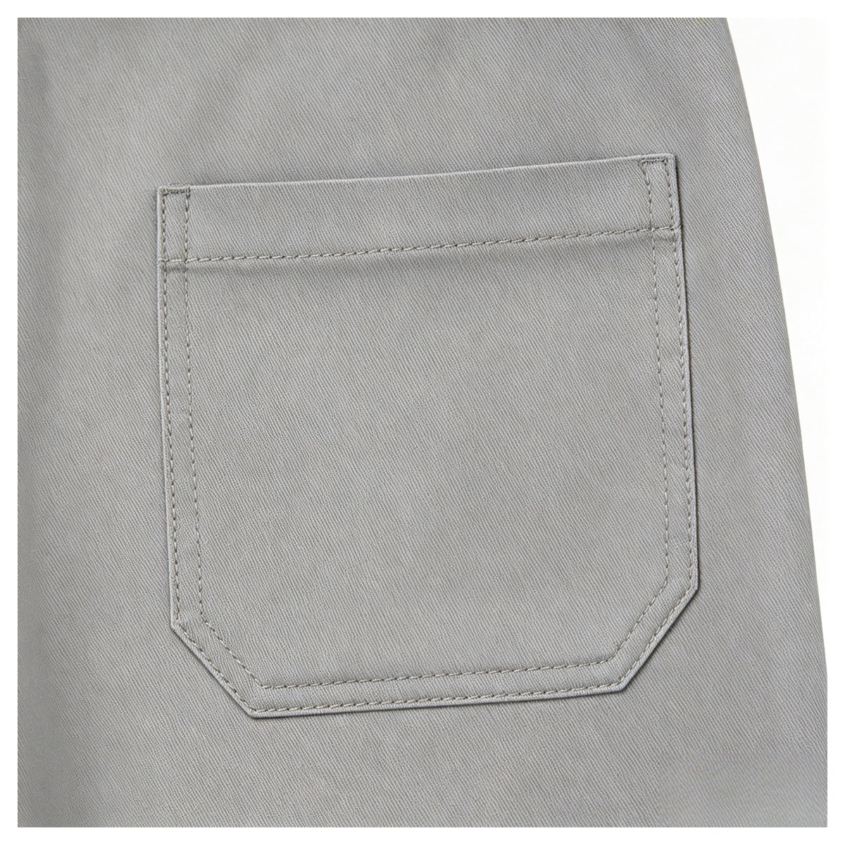 Close-up of a large stitched patch pocket on light gray fabric.
