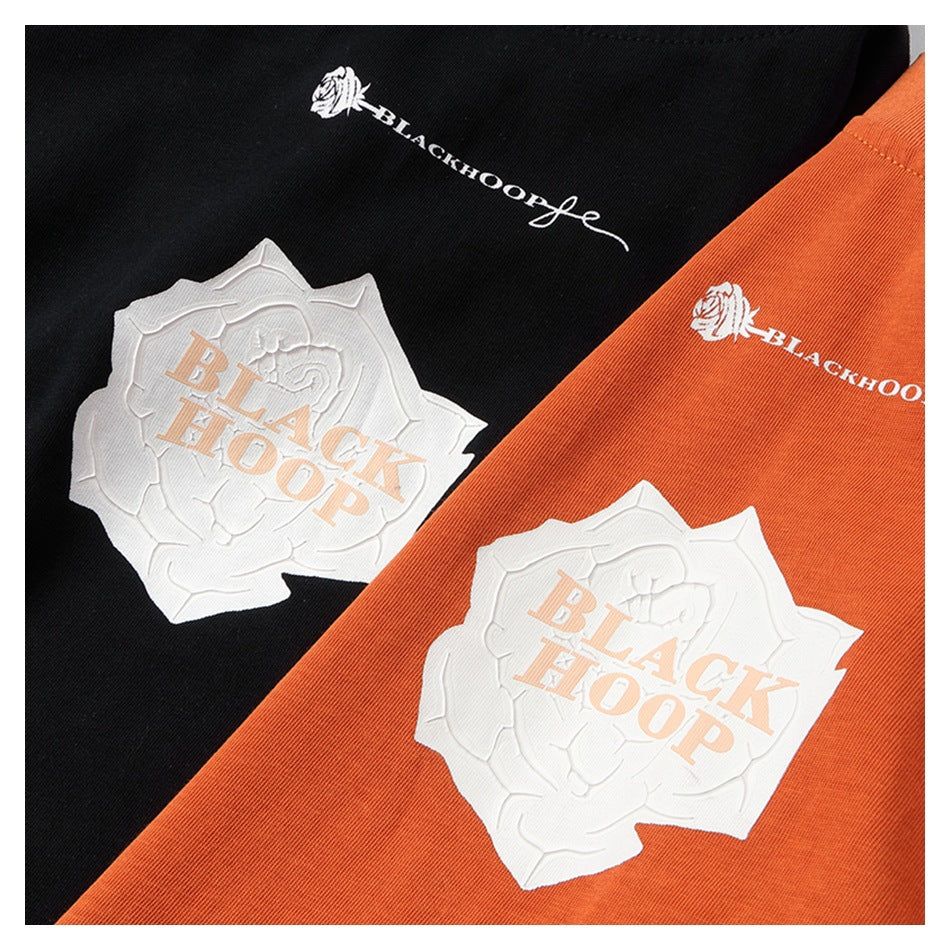 Close-up of black and orange garments with white graphic prints and BLACKHOOP lettering.