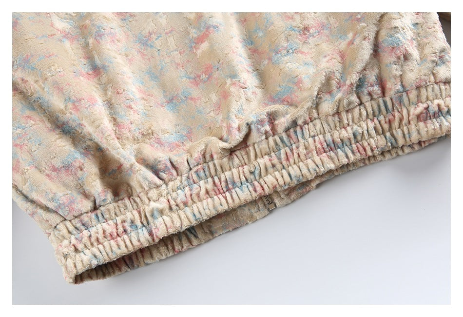 Close-up of the jacket's gathered elastic hem and cream fabric with pink and blue mottling.