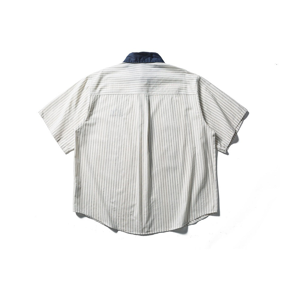 Back view of off-white striped short-sleeve shirt with navy collar, back yoke and center pleat