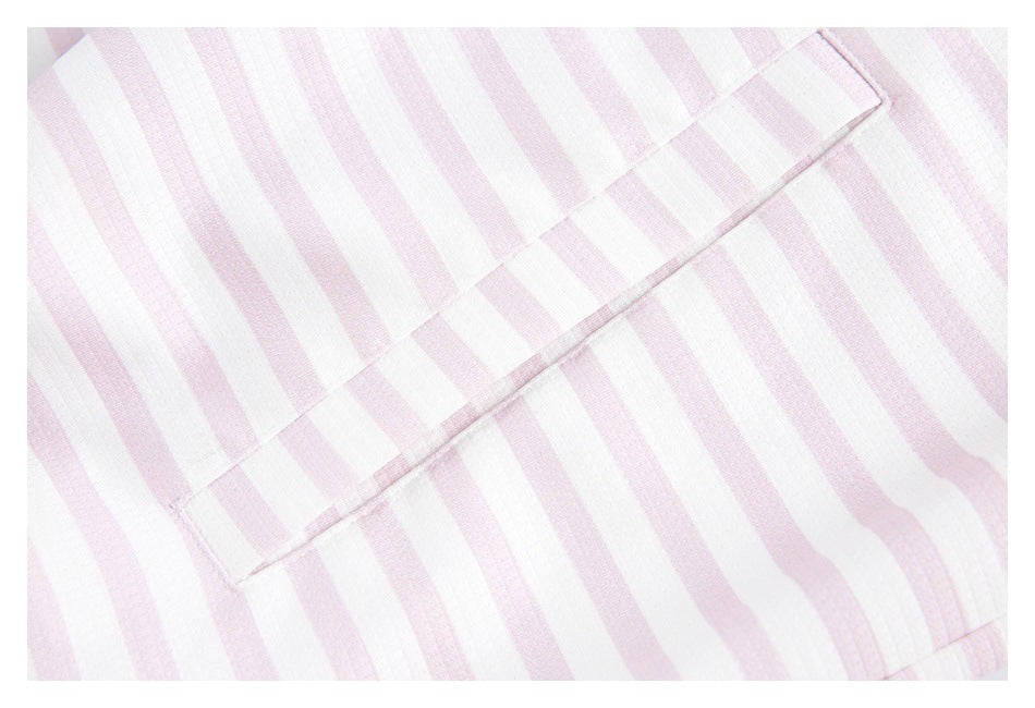 Close-up of a stitched panel seam across pale pink and white striped fabric.