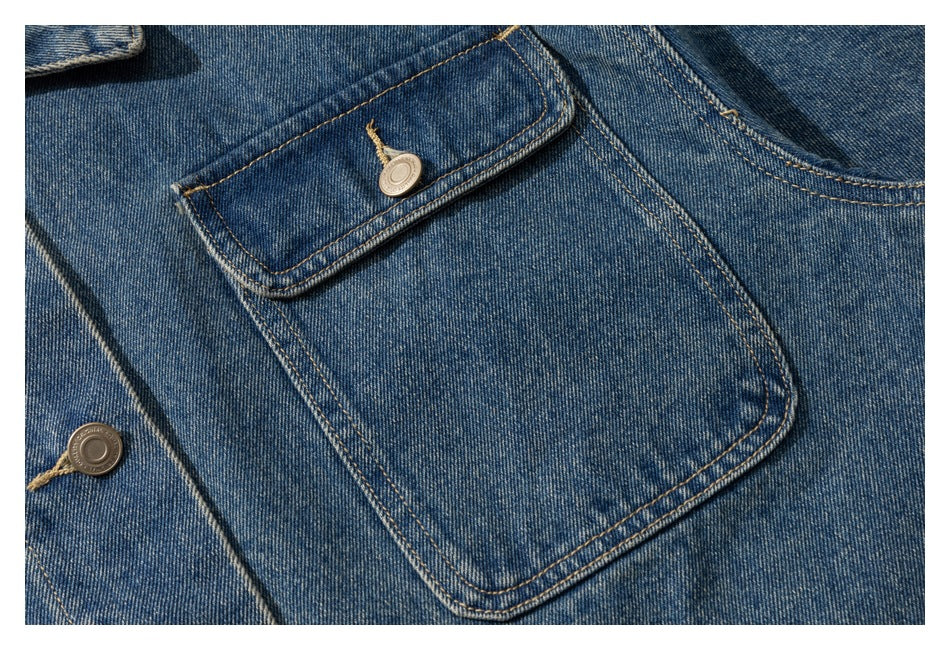 Close-up of a large patch pocket with a buttoned flap and contrast stitching on blue denim.