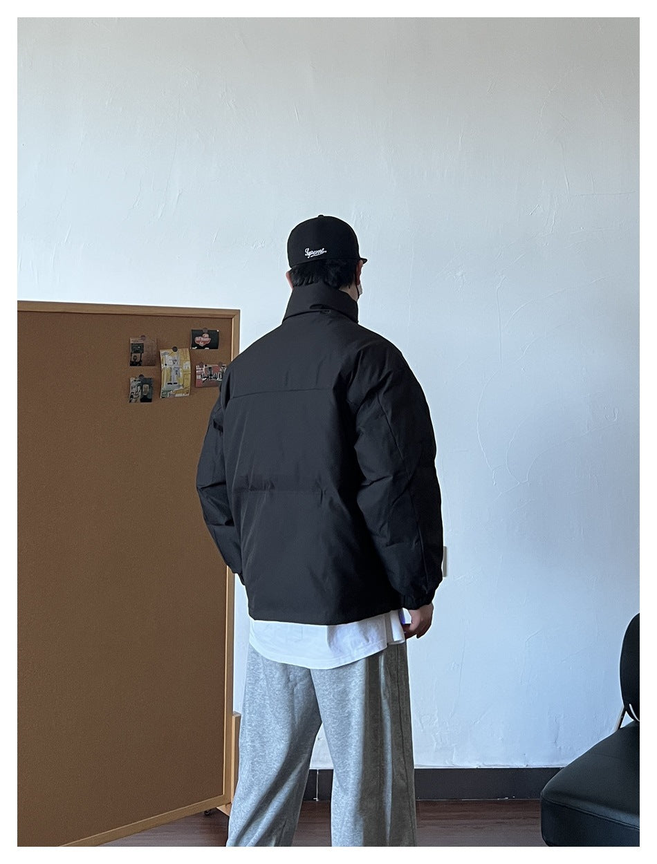 Back view of person wearing black stand-collar puffer jacket with white tee and gray sweatpants