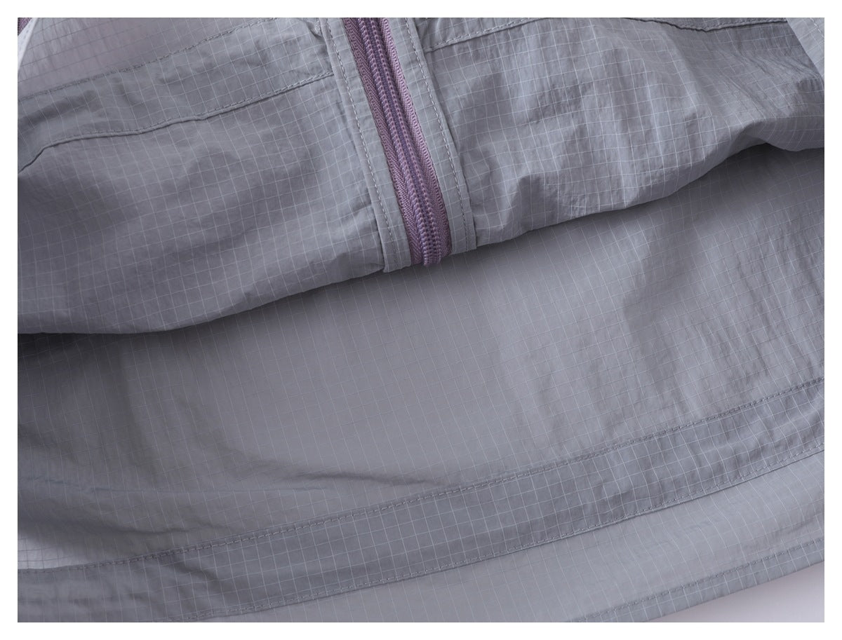 Close-up of the gray grid-patterned jacket back with horizontal seams and a lavender zipper.