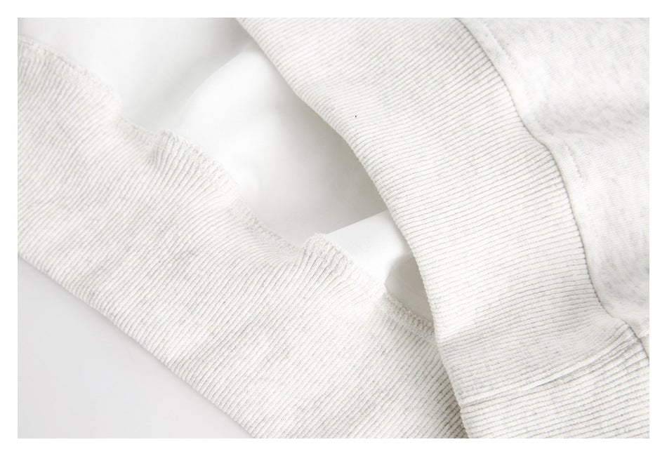 Close-up of the ribbed cuff and hem edge on a light gray garment.