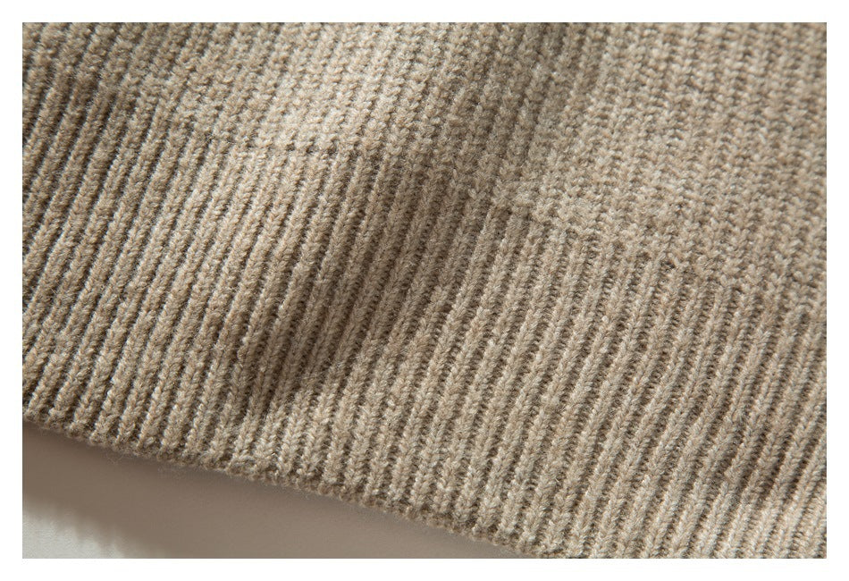Close-up of the beige sweater's ribbed knit fabric and hem.