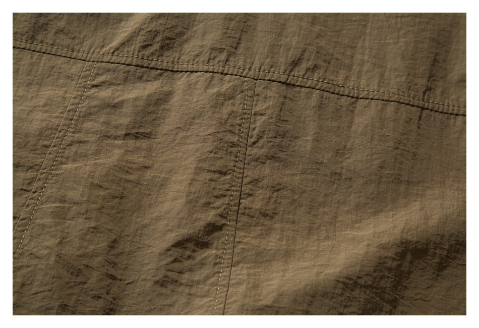Close-up of brown crinkled fabric with parallel stitching and a vertical panel seam.