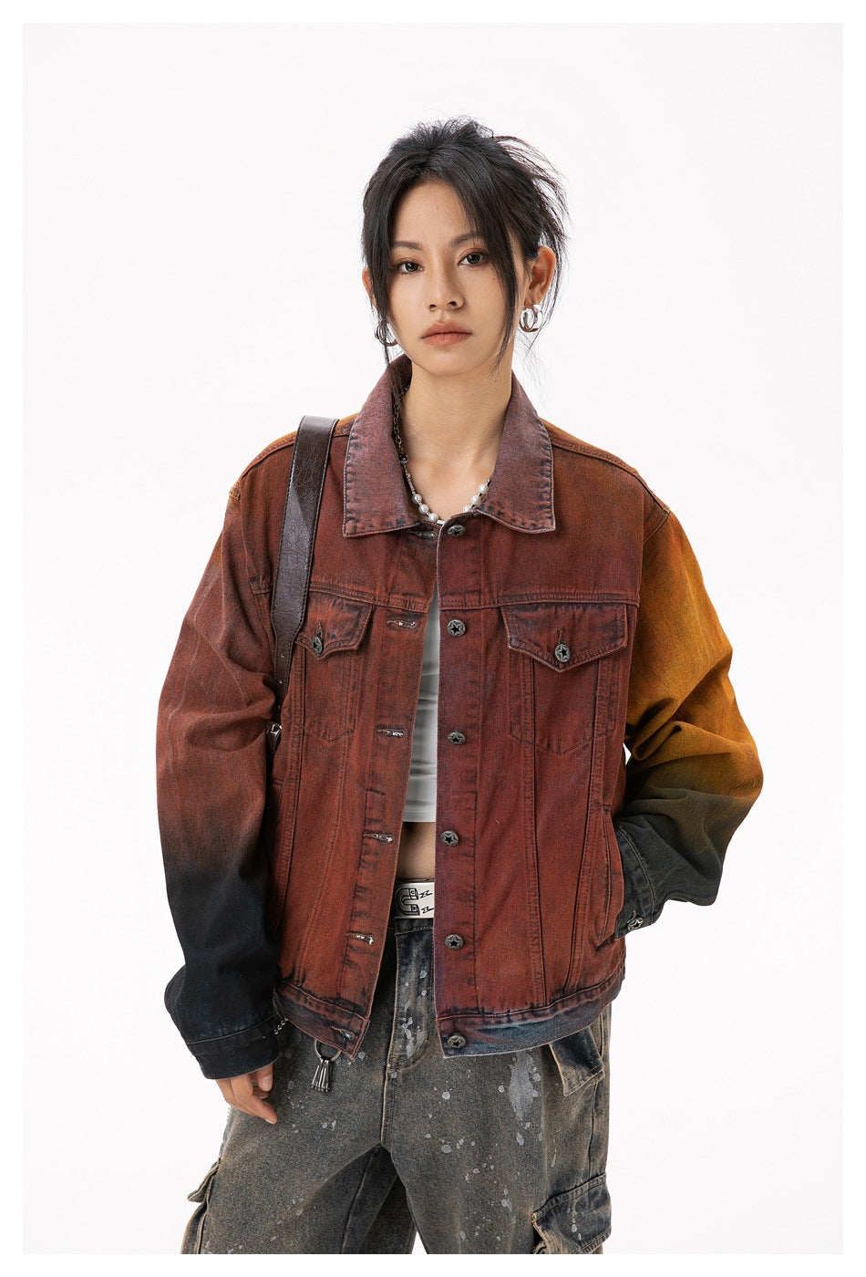 Model wearing a rust-red denim jacket with mustard and black gradient sleeves, front button closure, and chest pockets.