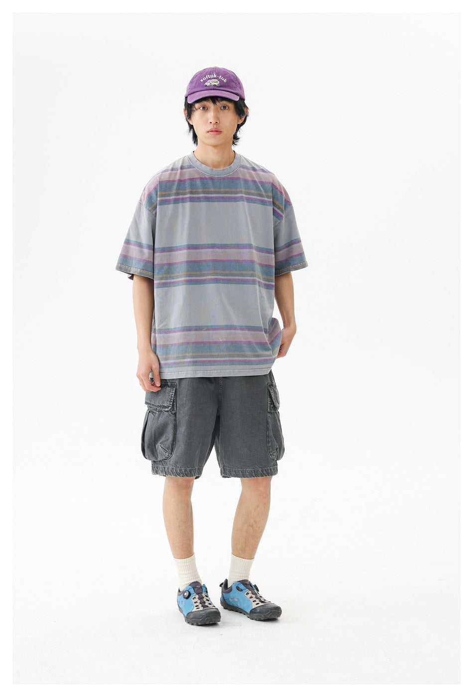 Front view of a model wearing an oversized gray T-shirt with muted purple, blue, and tan stripes.