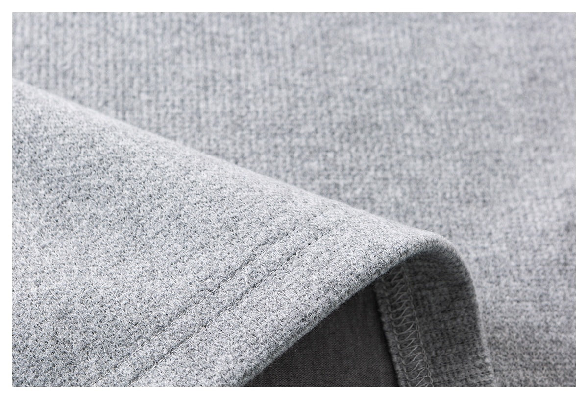 Close-up of a folded light gray garment edge, showing the stitching and overlocked underside.