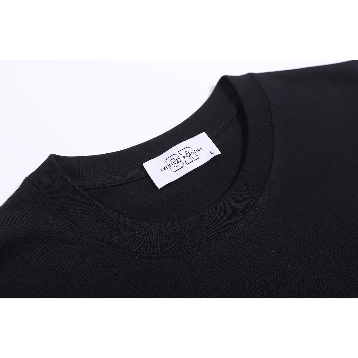 Close-up of a black T-shirt’s ribbed crew neck and sewn-in white label.