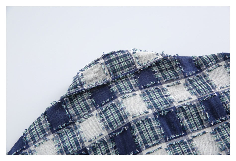 Close-up of a curved folded edge and frayed patchwork plaid fabric in blue, green and white.